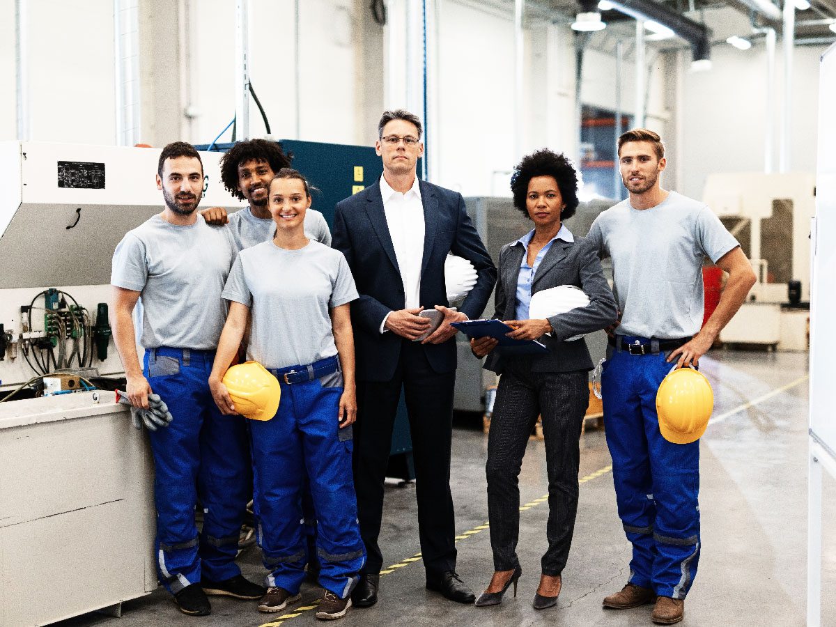 portrait-group-engineers-corporate-managers-standing-factory-looking-camera